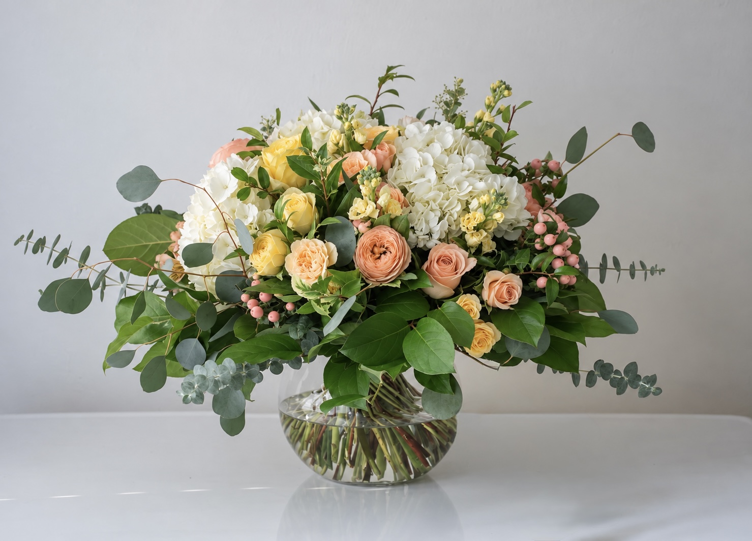 EuroFleur Signature Arrangement in blush, cream and soft pink in a clear glass vase
